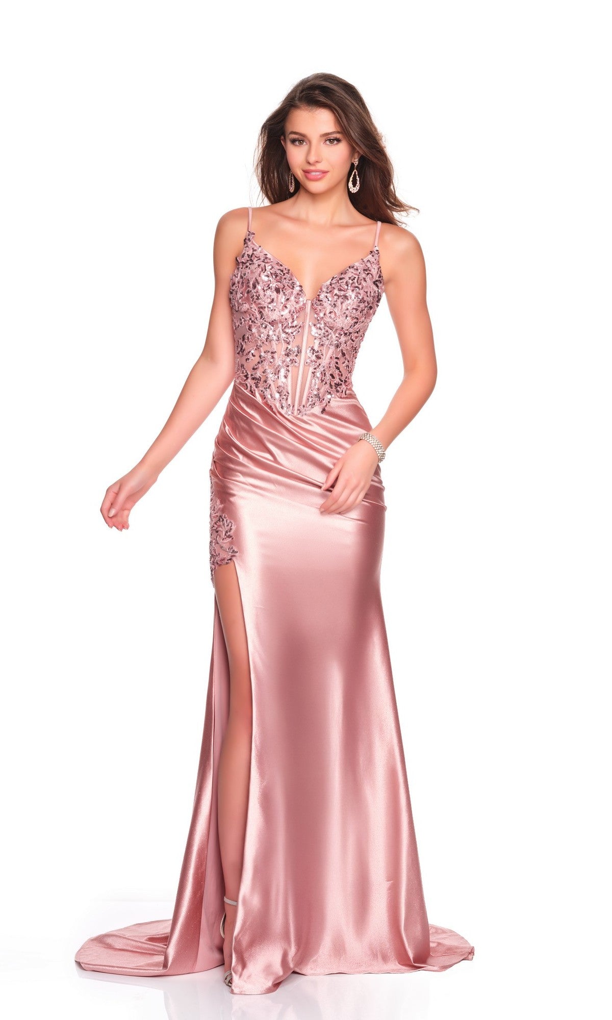 A woman in the Dave and Johnny 12601 long prom dress—a blush pink satin gown featuring a fitted silhouette, embroidered corset bodice with floral detail, spaghetti straps, deep neckline, and high leg slit—makes a stunning statement.